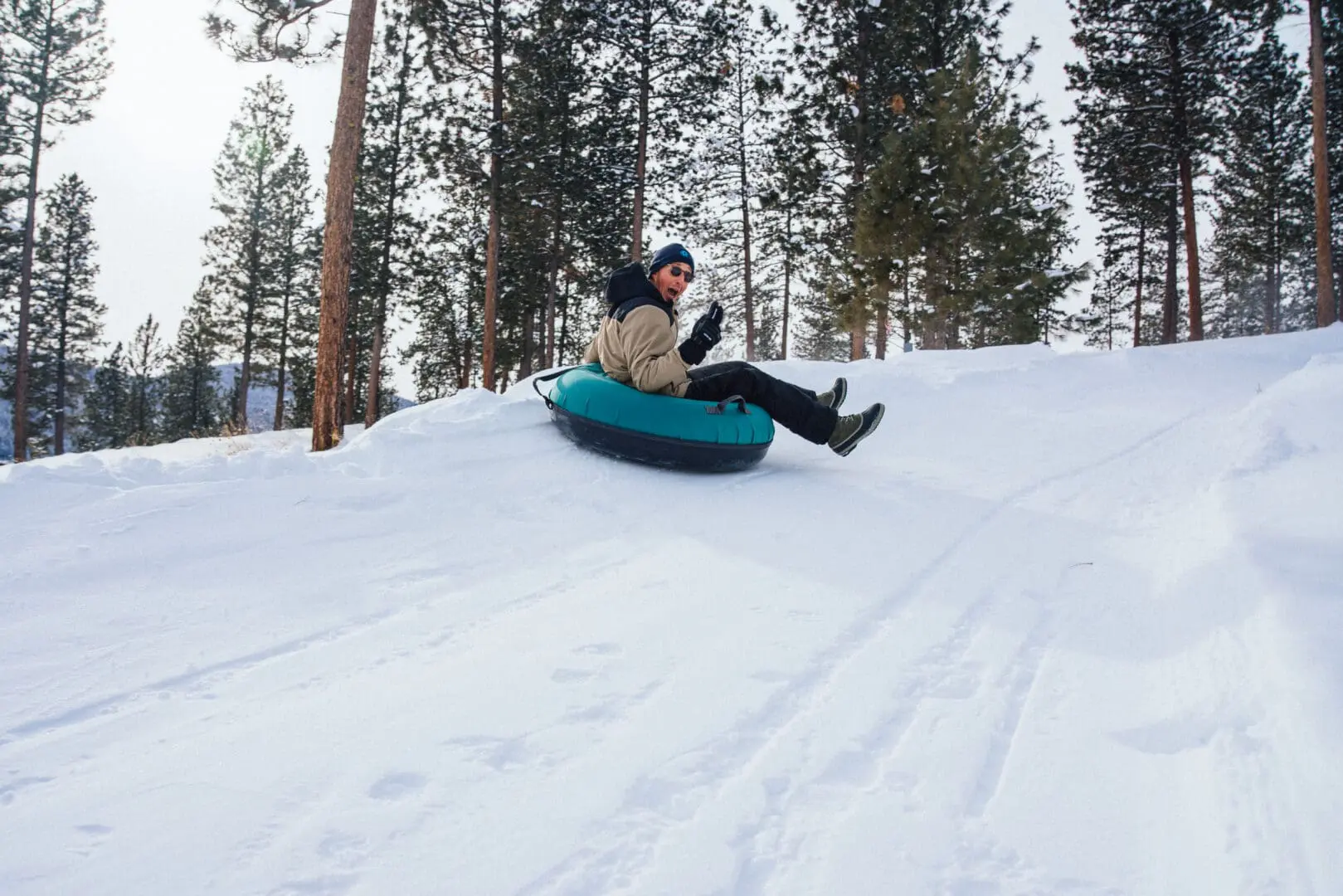Man tubing down a snow hill.