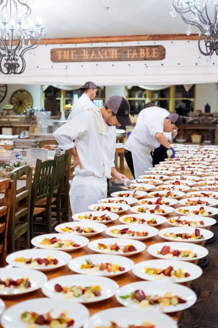 Line of dishes being plated by several chefs in the Trough restaurant at Paws Up Montana