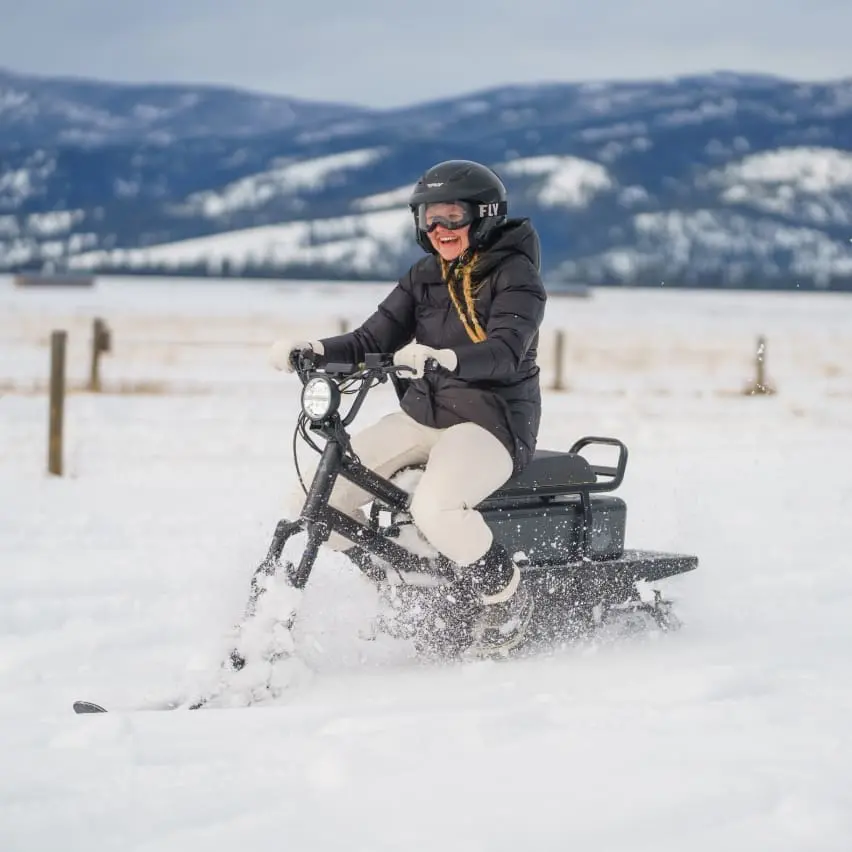 Eager driver riding a moonbike (electric snowbike) through the winter mountain snow