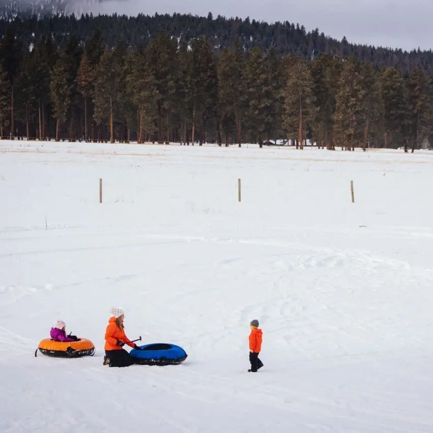 Family at the bottom of of the tubing hill in the snow