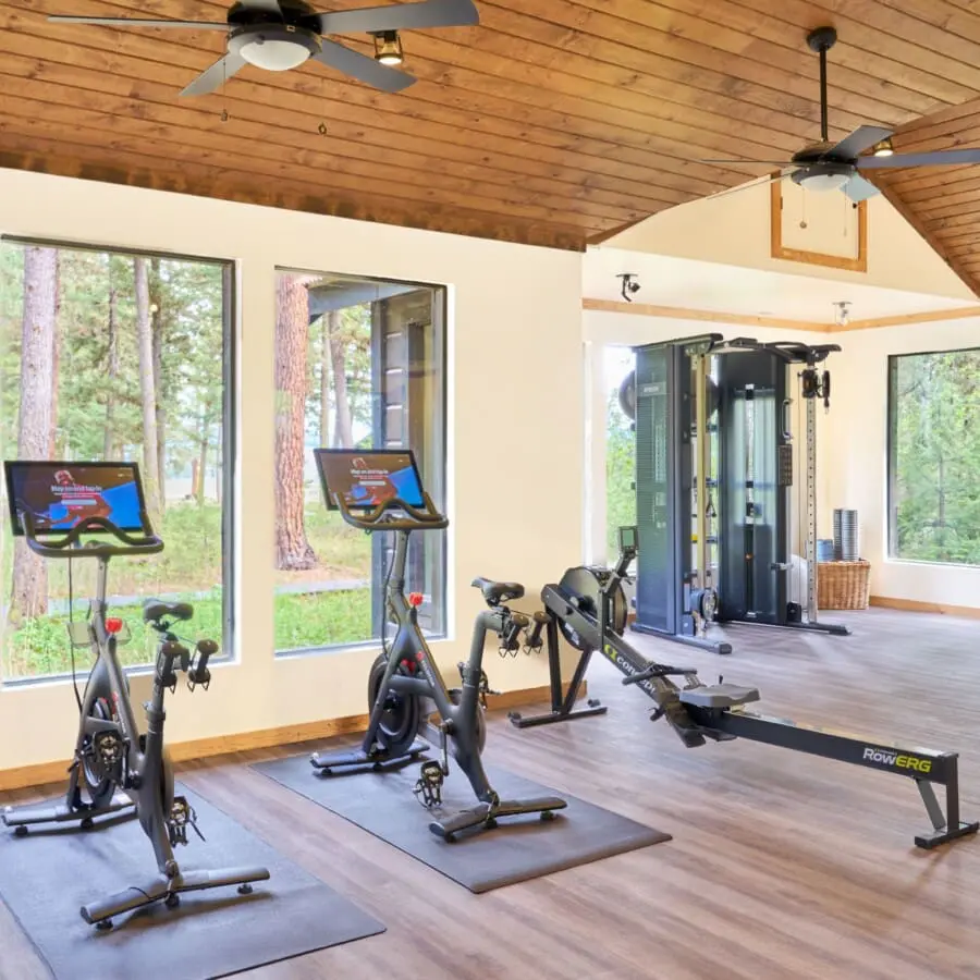 Huff-and-Puff Fitness Center with two stationary bikes, a rowing machine, and a squat rack with beautiful mountain views out of the windows