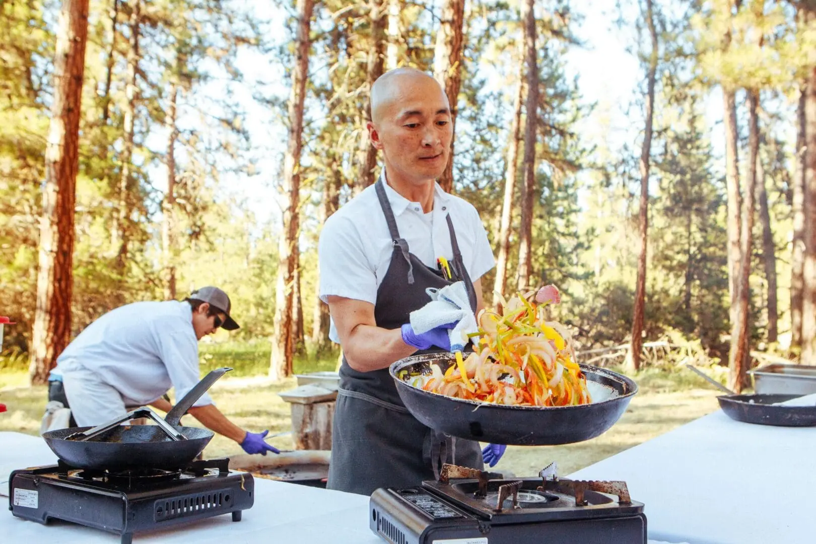 Chef Sunny grilling peppers and onions outside in the forest for the Bounty on the Blackfoot event at Paws Up Montana