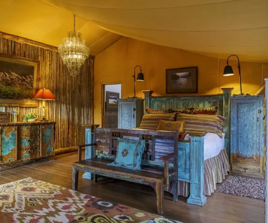 Western-style king bed inside glamping tent