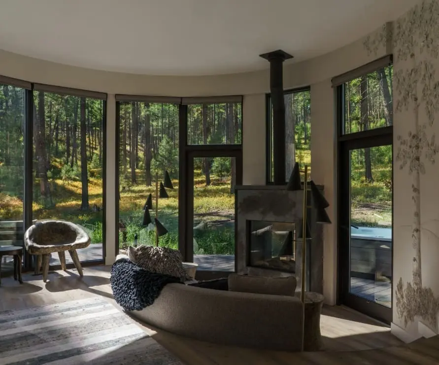 Inside view of Round Haus in Green O, showing the windowed living room with a fireplace and couch