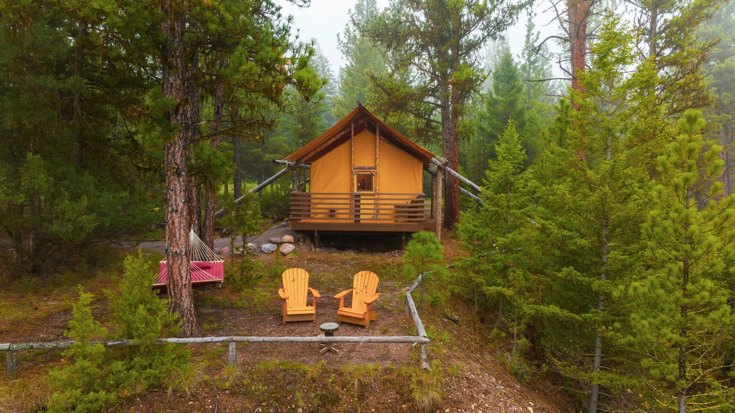 Exterior of luxury canvas glamping tent with porch and hammock