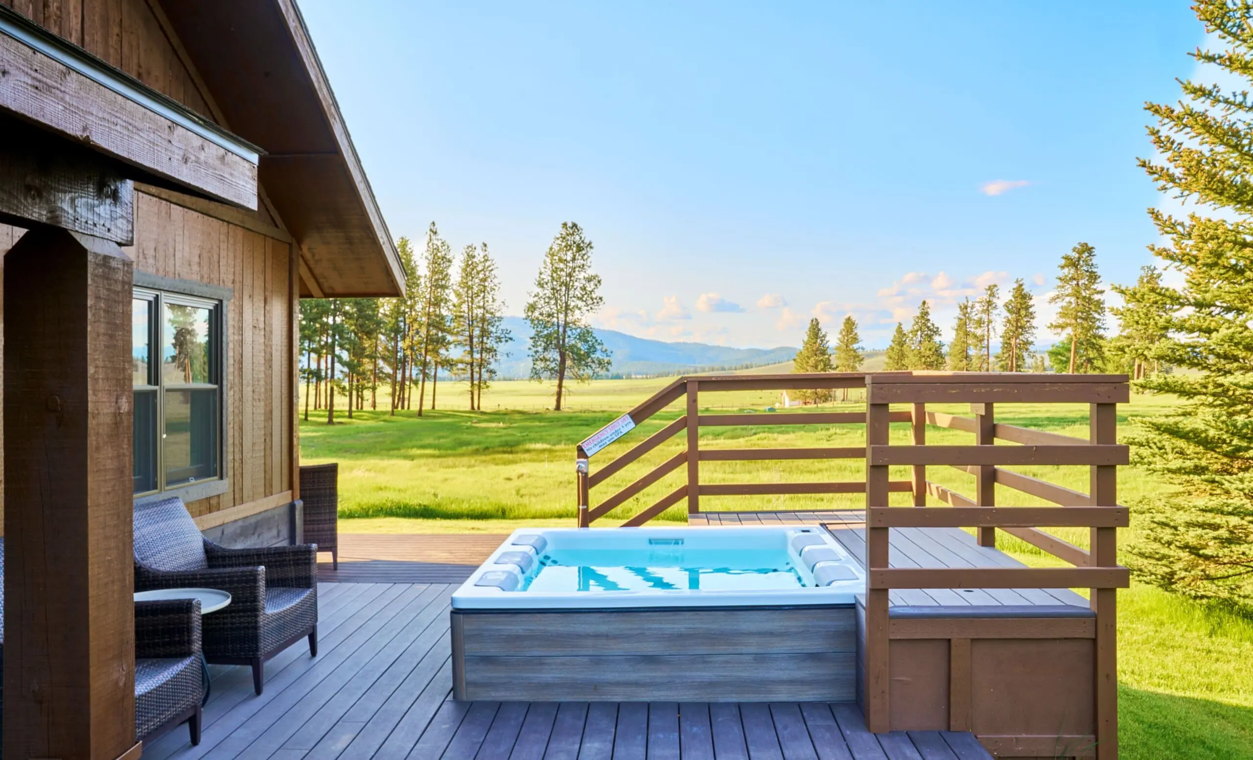 exterior of cabin porch with hot tub and meadow view