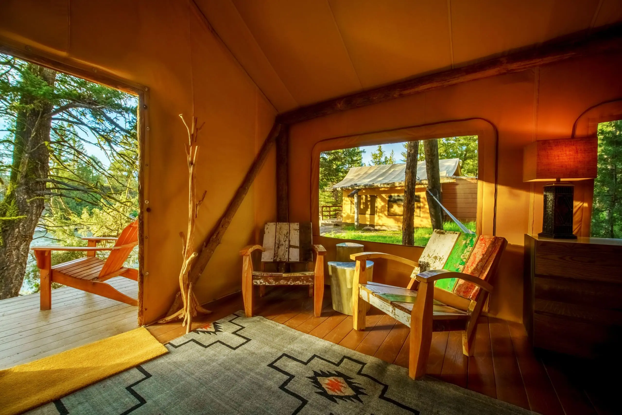 Wooden armchairs inside a canvas glamping tent