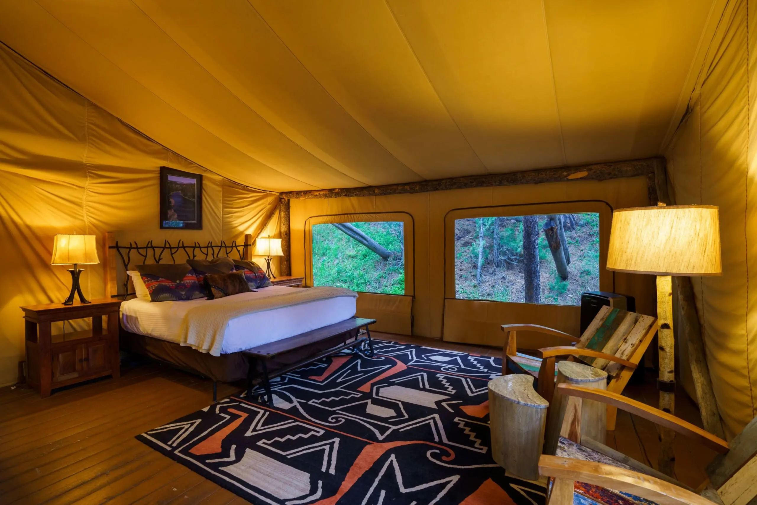 Interior of a luxury camping tent bedroom with a king size bed