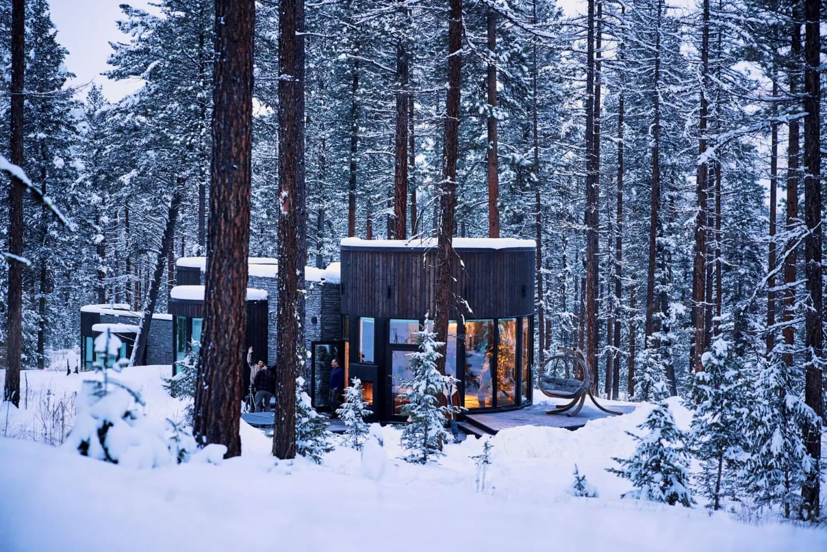 Winter exterior of round modern cabin in the forest