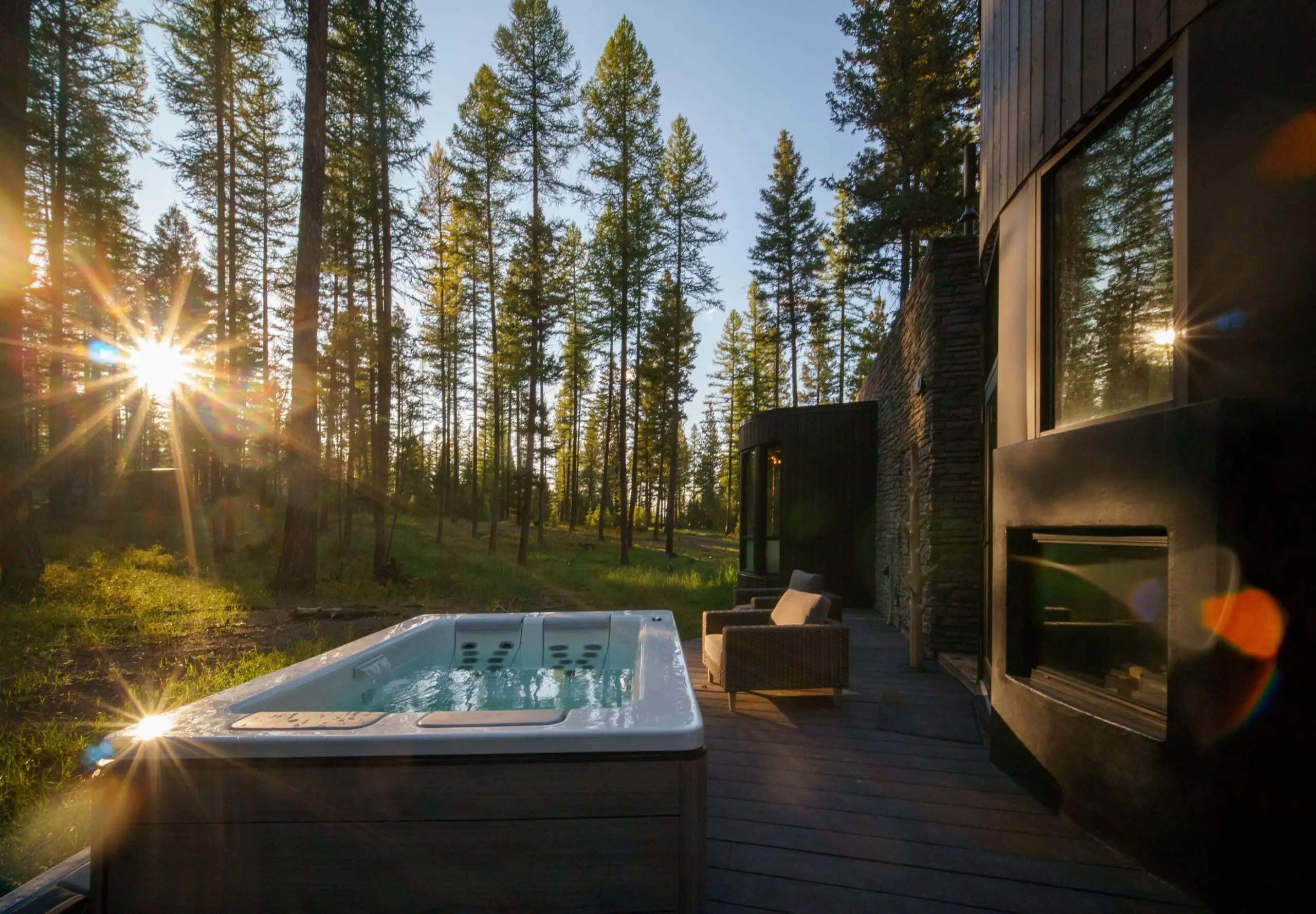 Exterior of modern cabin deck in the forest with hot tub