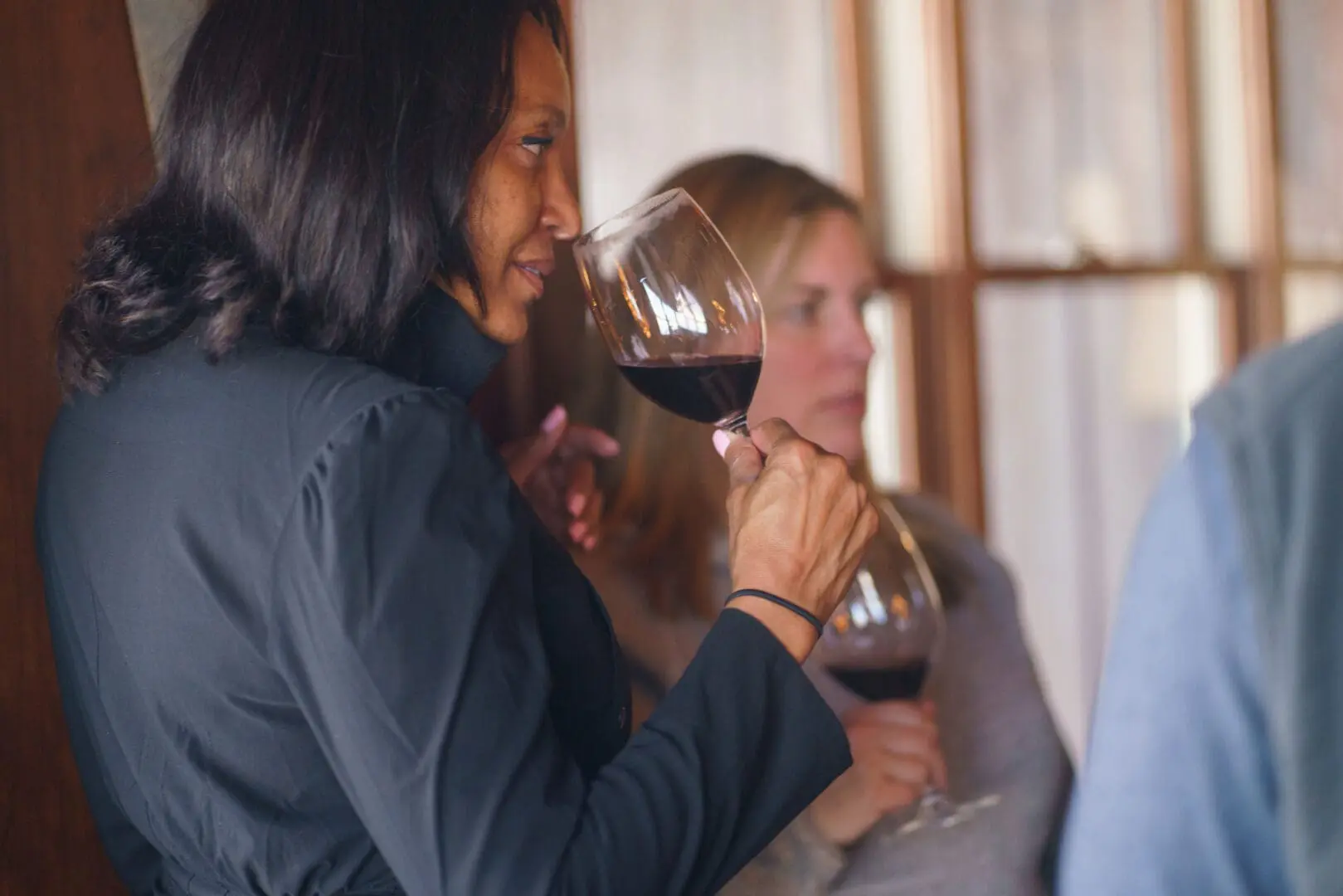 Woman smelling wine from a wine glass.