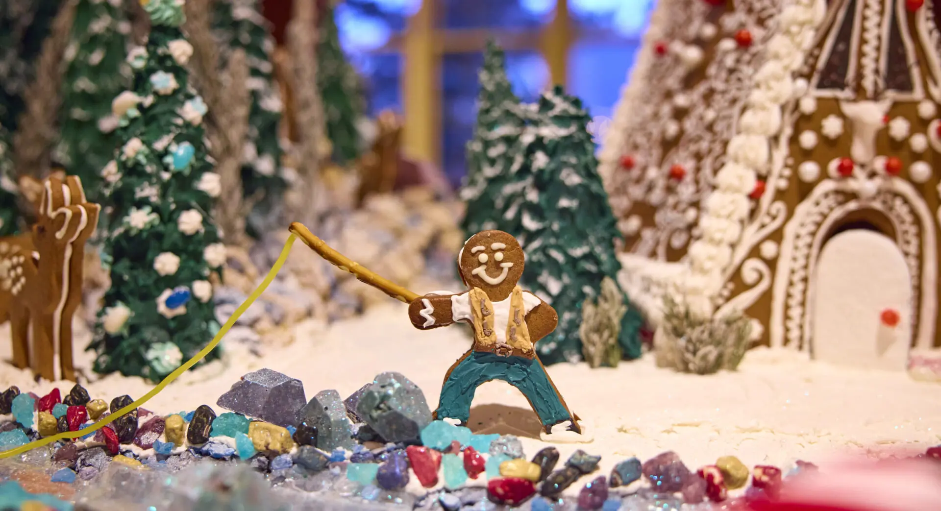 Gingerbread man fishing over a gingerbread river in his gingerbread village.