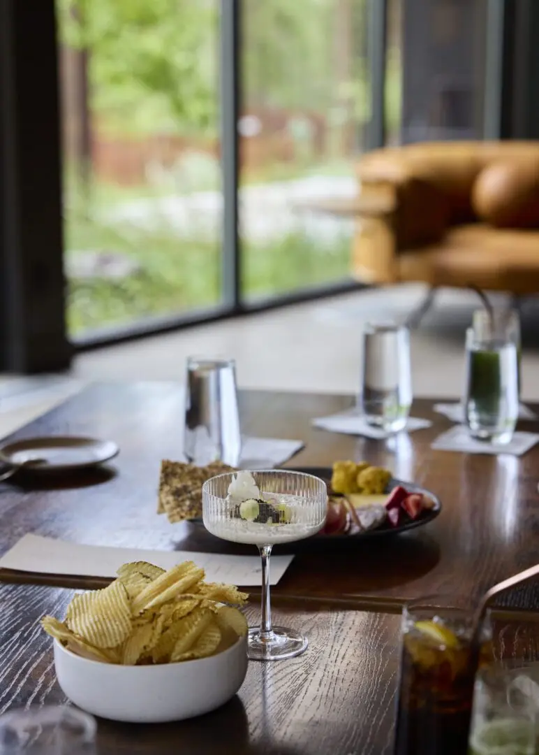 Fries and drink sitting on a nice table inside a windowed area.