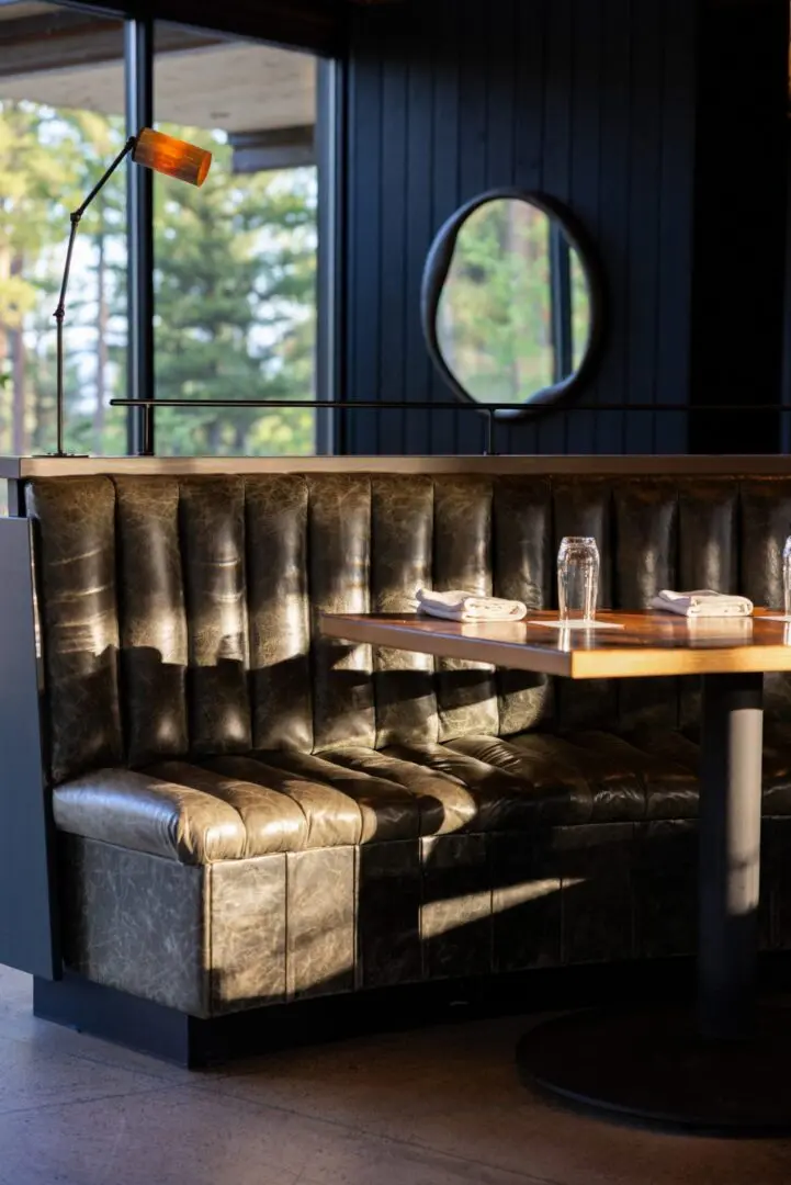 A leather booth inside of a dark restaurant.