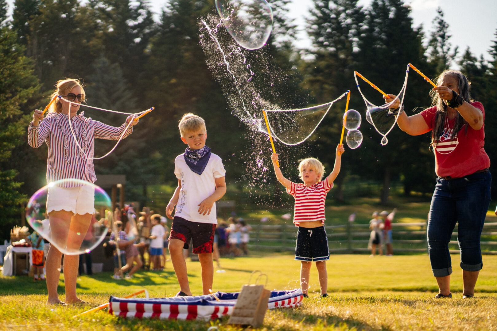 Fourth of July photo of kids playing with large bubble makers outside