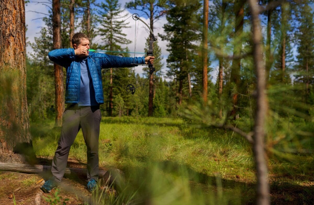 Man shooting bow and arrow in the forest