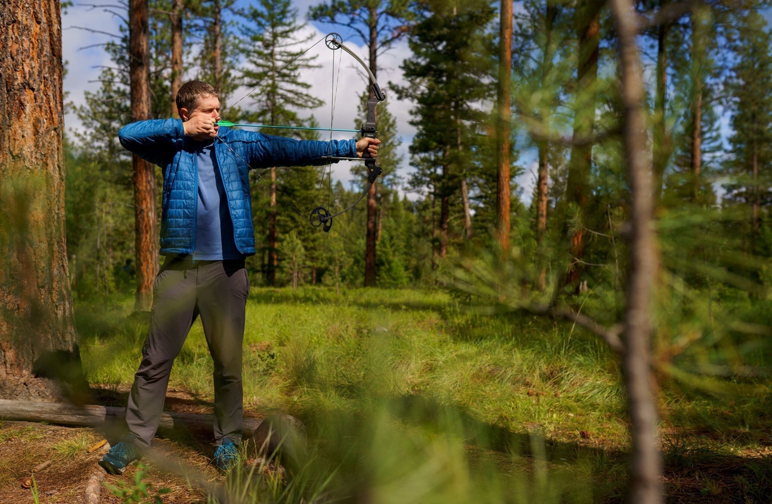 Man shooting bow and arrow in the forest