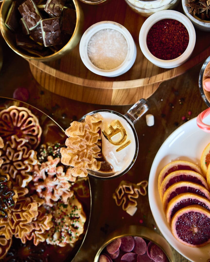 Array of hot chocolate add-ins and a branded hot chocolate with cookies.