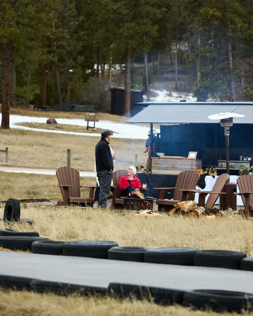 Parents sitting outside watching their children race on an outdoor race track.