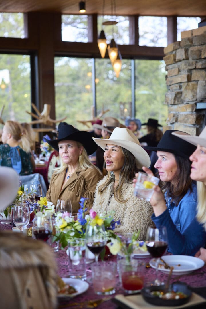 Women sitting at a table in western style clothing.