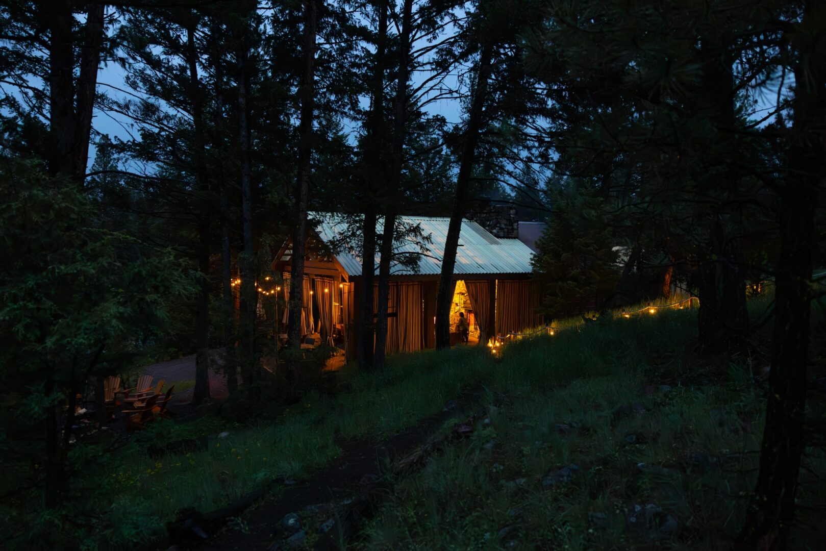 A dark pavilion surrounded by trees and lights.