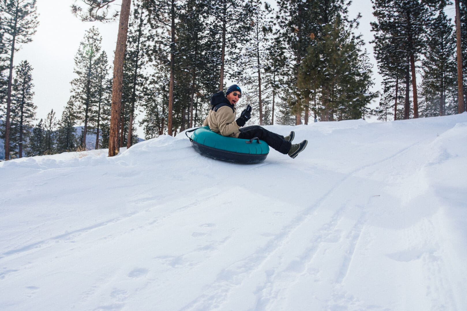 Man tubing down a snow hill.