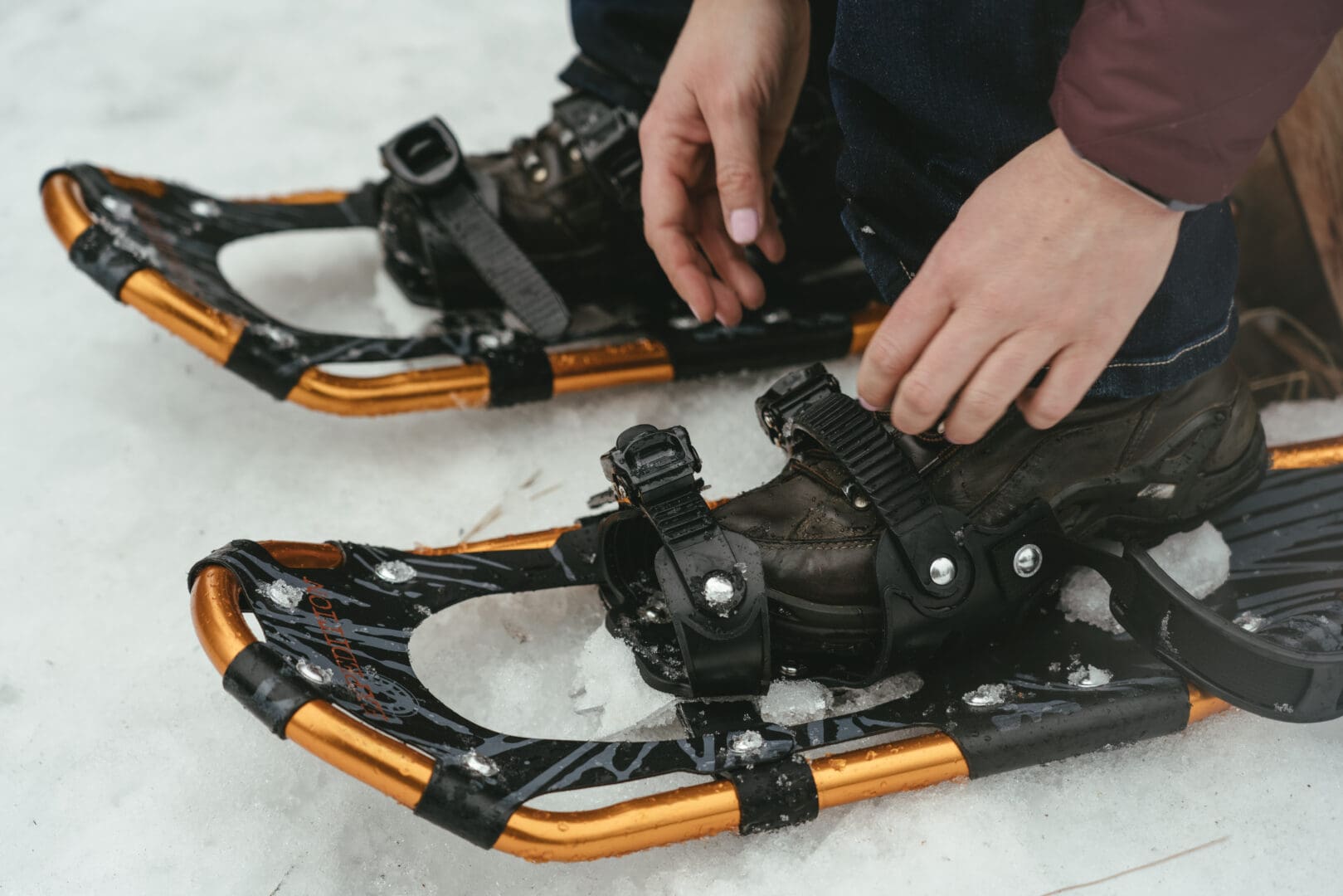 Shot of individual putting on the snowshoes.