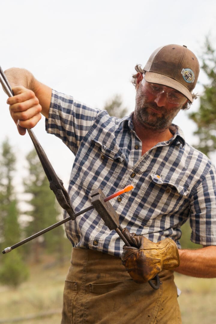 Metal smith firing up a rod.