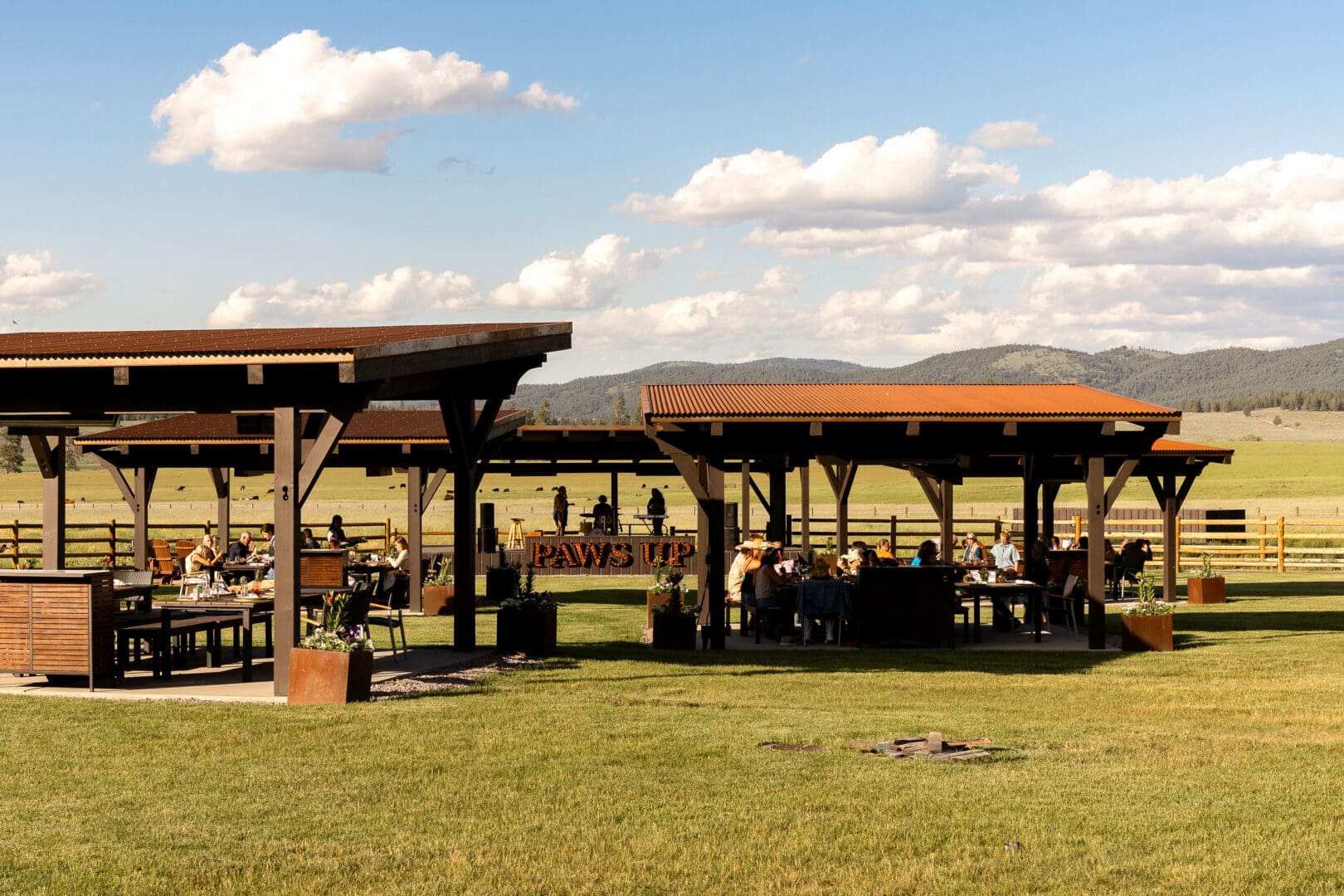 A green yard with wooden pavilions.