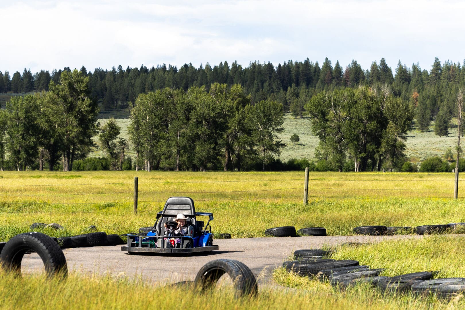 Kid in a go-kart on an outdoor track.