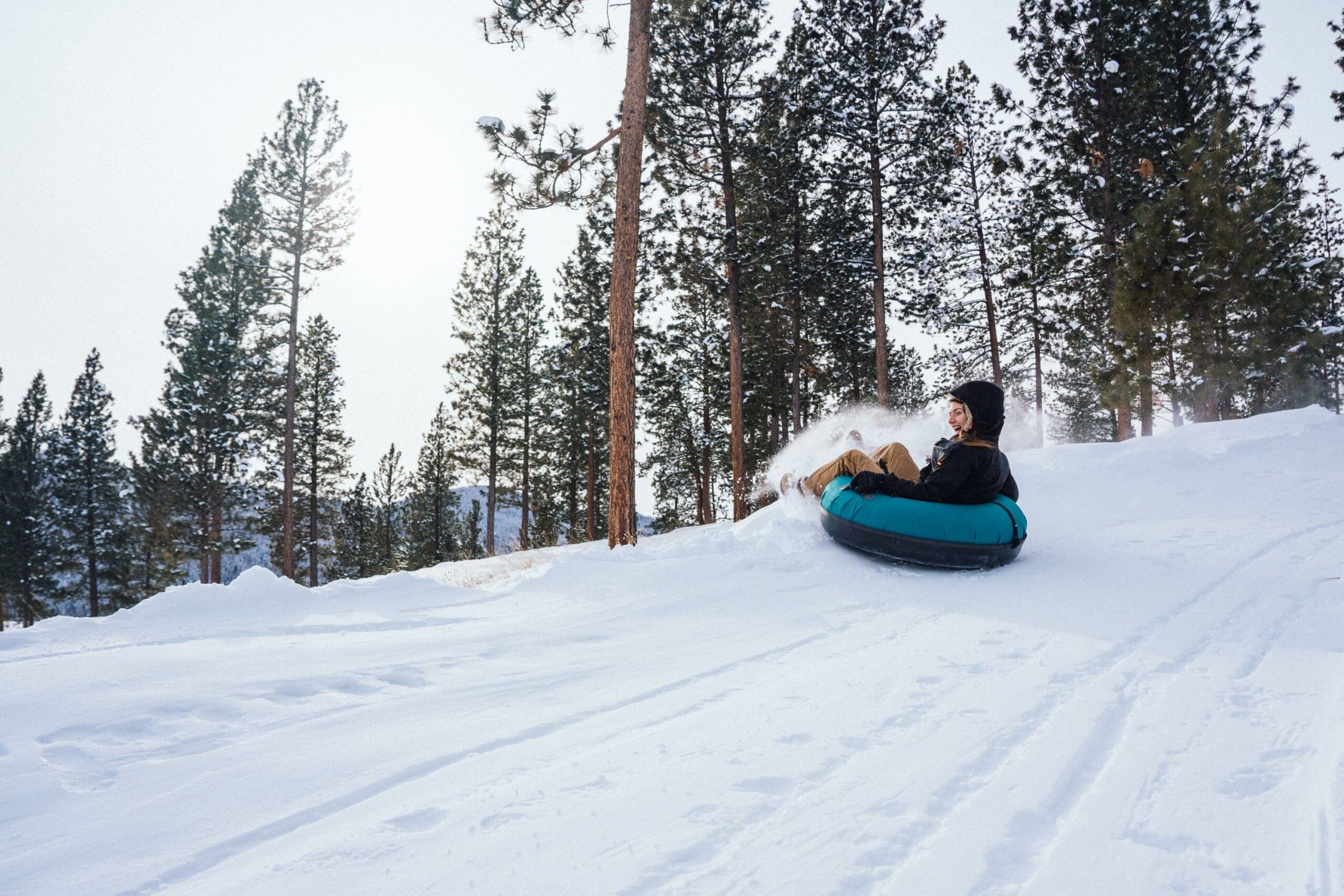 Person tubing down Blast Mountain snow hill at Paws Up
