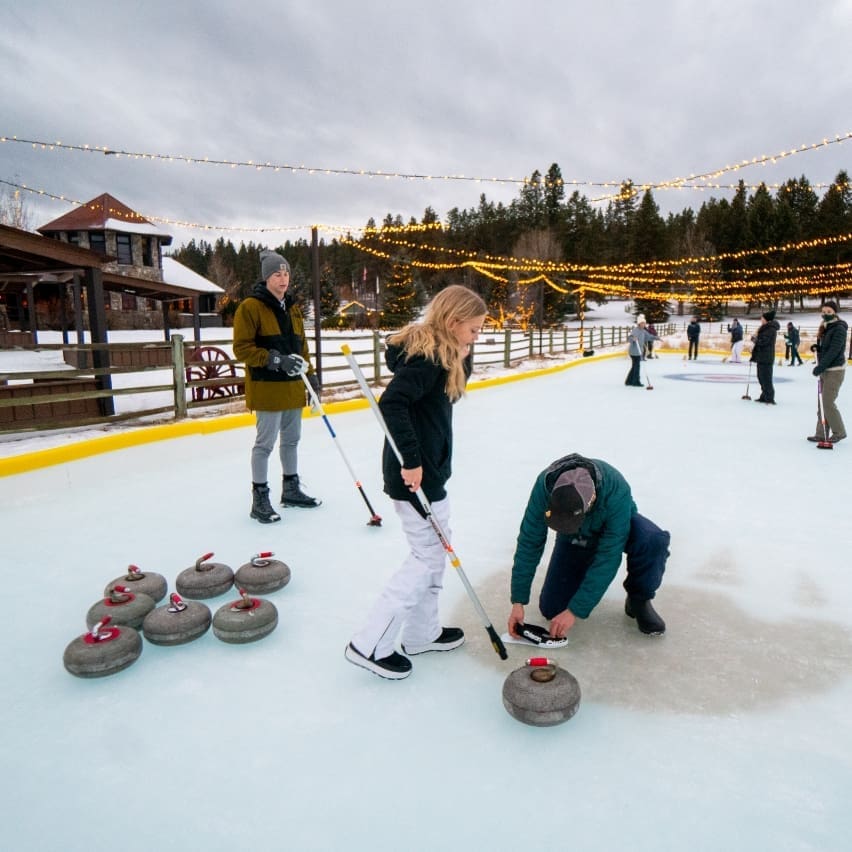 Family practicing curling in a skating rink