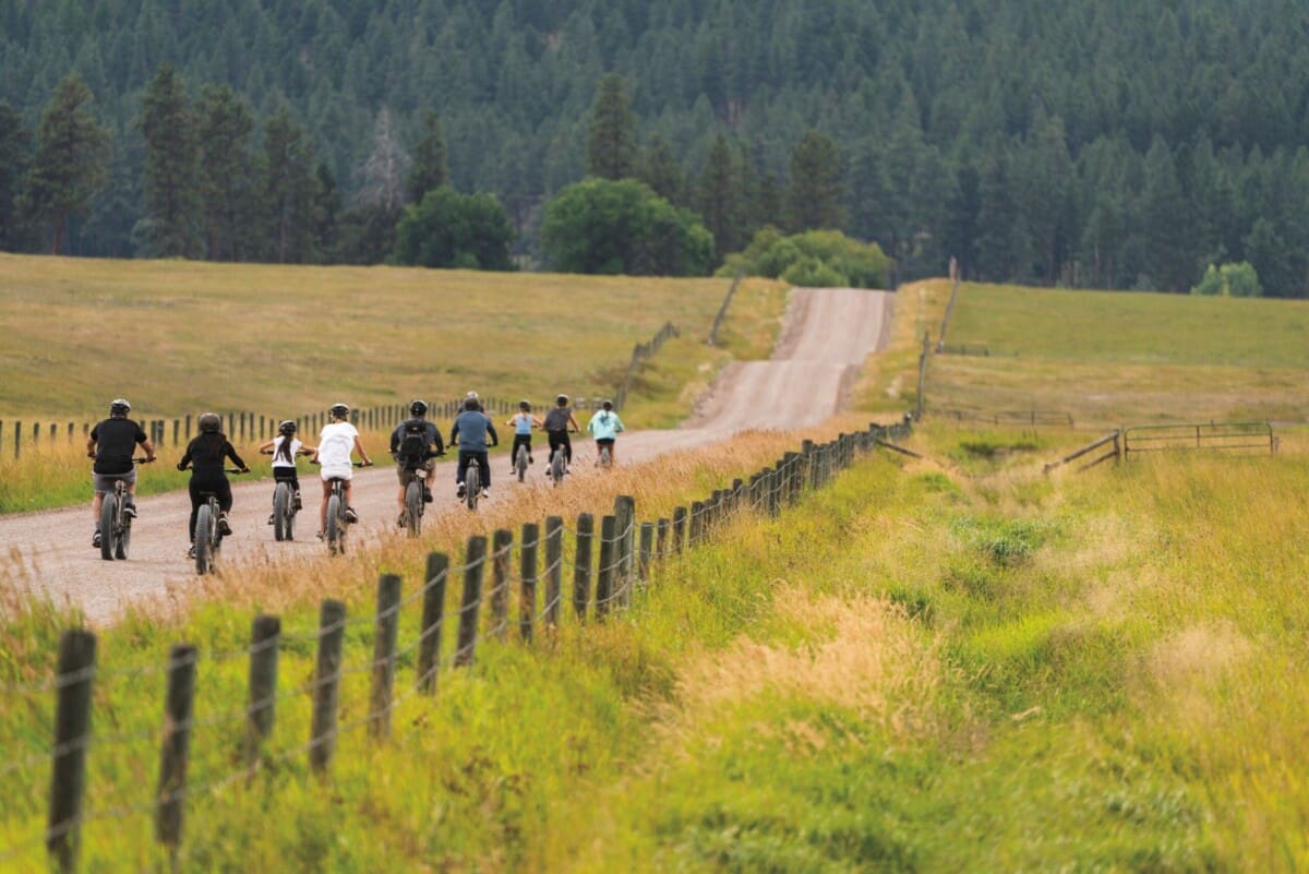 Family biking down a dirt road on ebikes