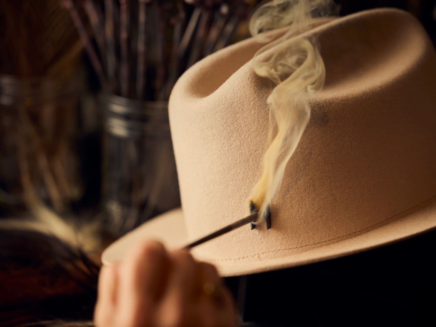 Smoking letter brand making a mark on a suede, beige cowboy hat