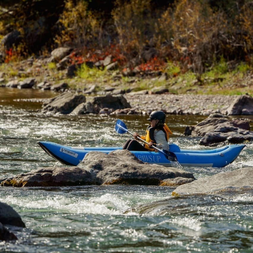 Person kayaking through a mountain river
