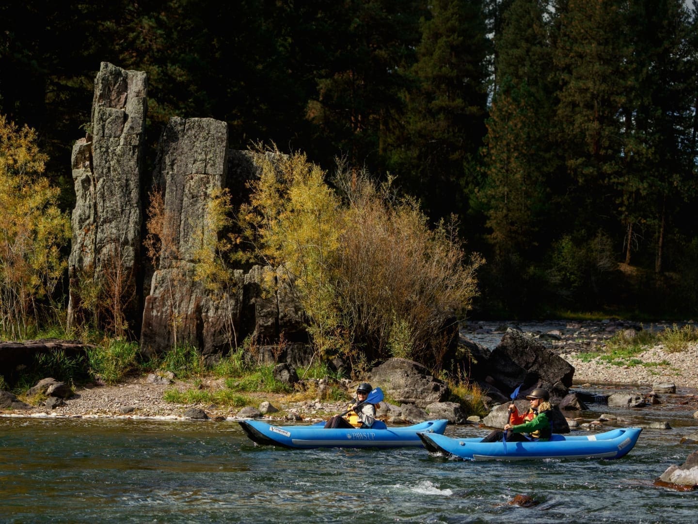 Two kayaks floating through a mountain river
