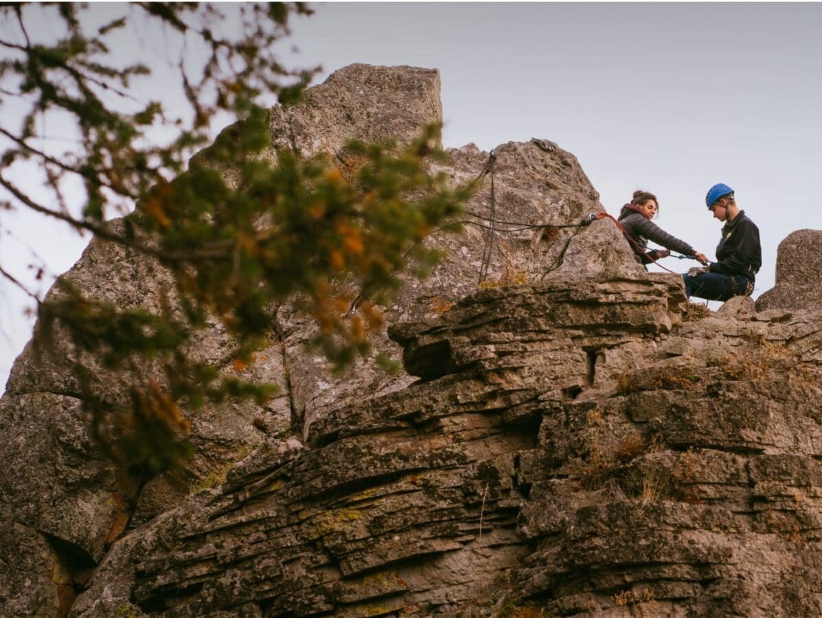 Two climbers looking down on a high rock they summited