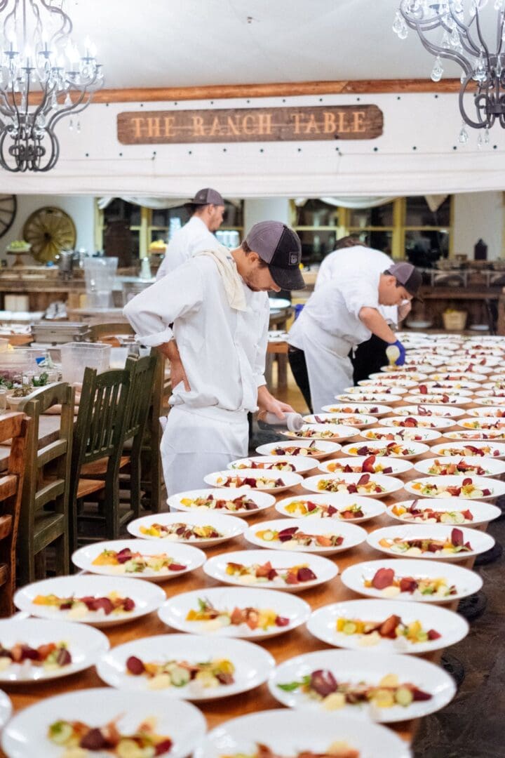 Line of dishes being plated by several chefs in the Trough restaurant at Paws Up Montana