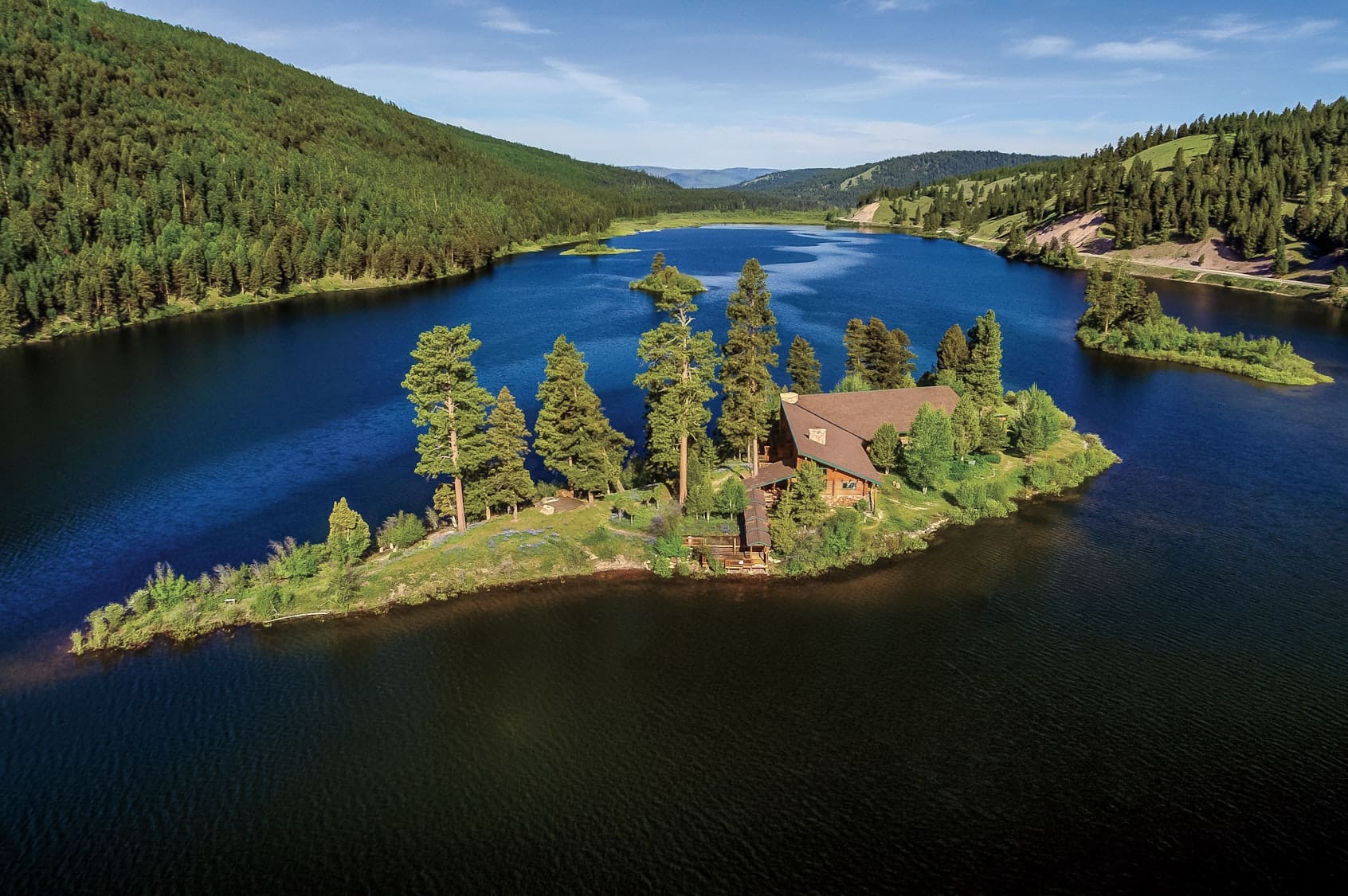 Shot of an island in the middle of a lake with a sunset in the background.