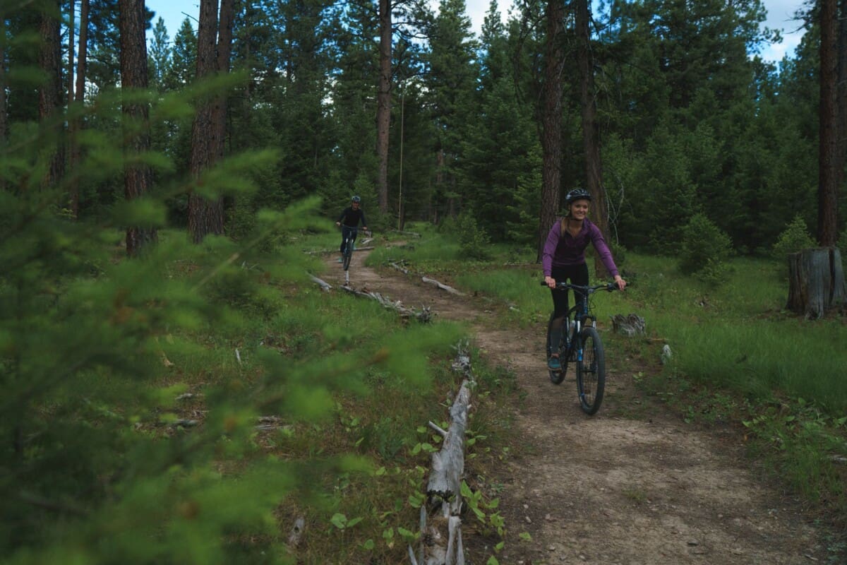 Woman mountain biking through the woods
