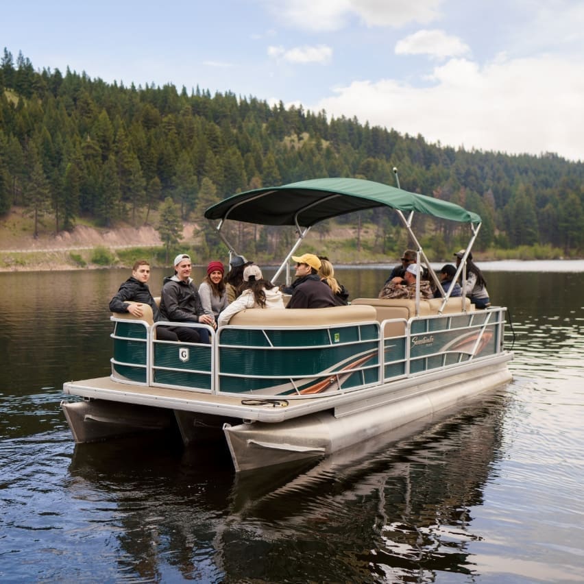 Group gliding through a mountain lake in a pontoon boat