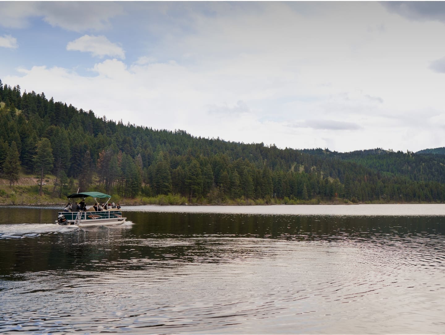 Pontoon boat cruising on a mountain lake