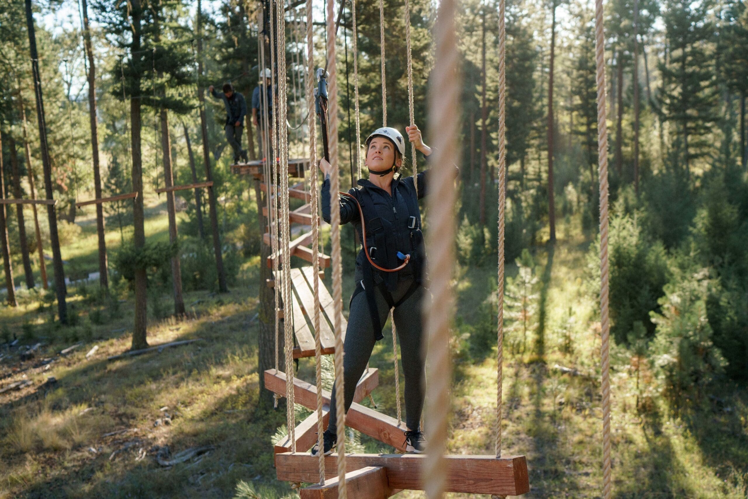 Woman climbing through ropes course in the Skyline Aerial Adventure Park