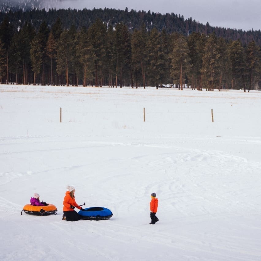 Family at the bottom of of the tubing hill in the snow