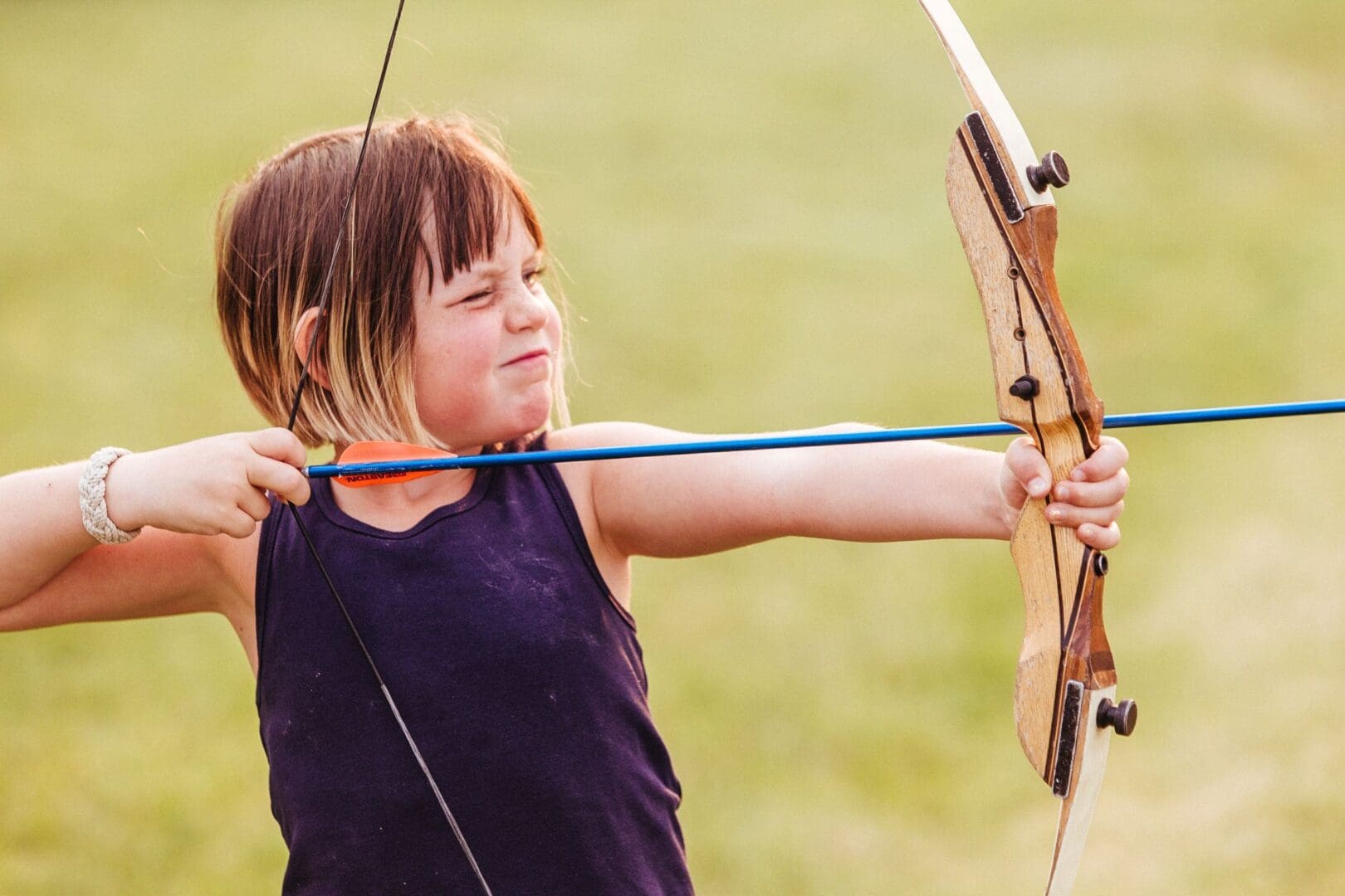 Little girl shooting a bow and arrow