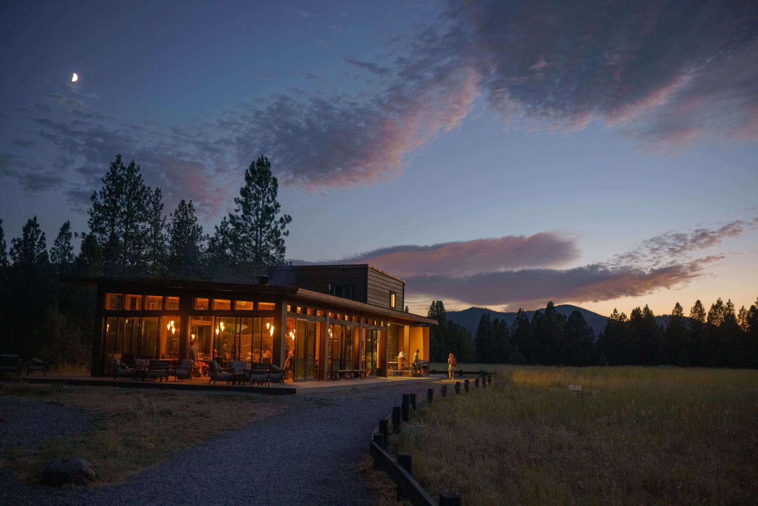 Sunset view of the Northbank Dining Pavillion at Paws Up, a modern, wooden private dining building