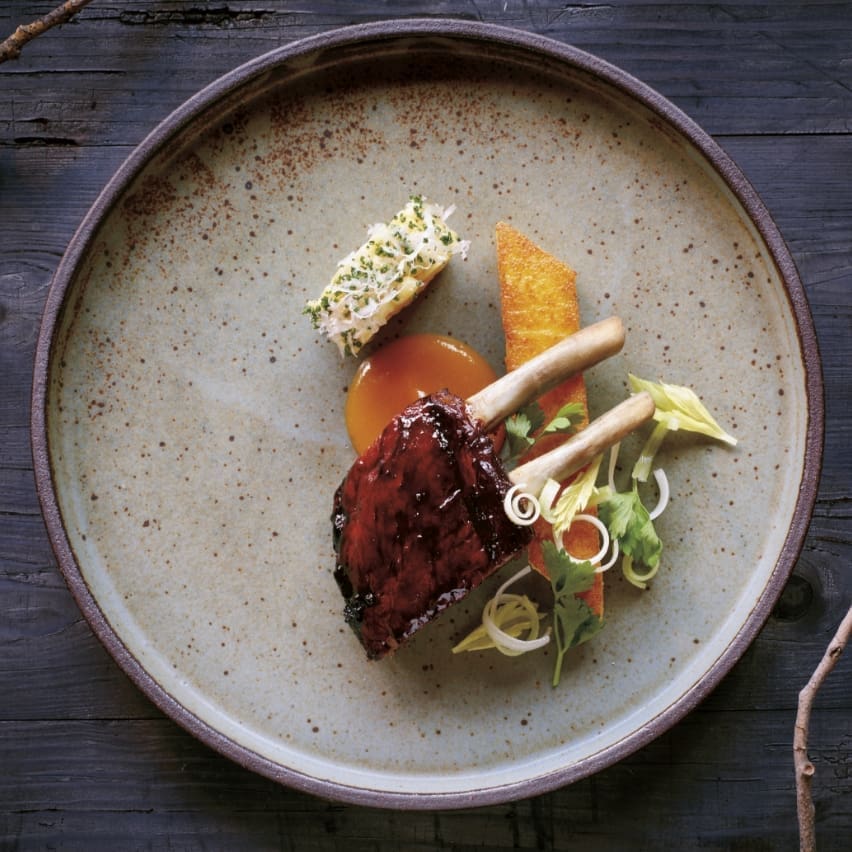Pork chops and vegetable garnish on a speckled gray plate