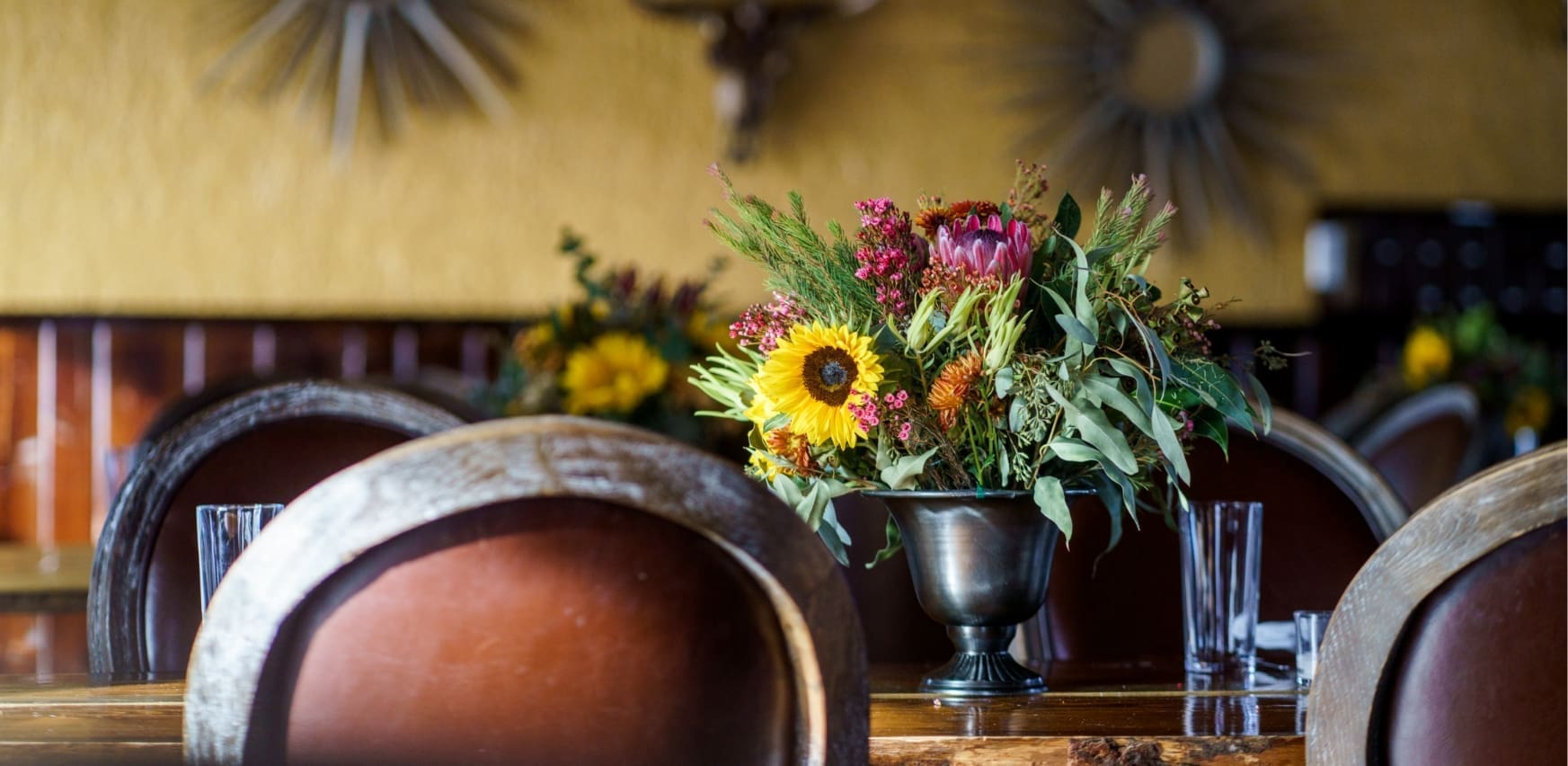 Sunflower and green bouquet on a wooden table in the Pomp restaurant