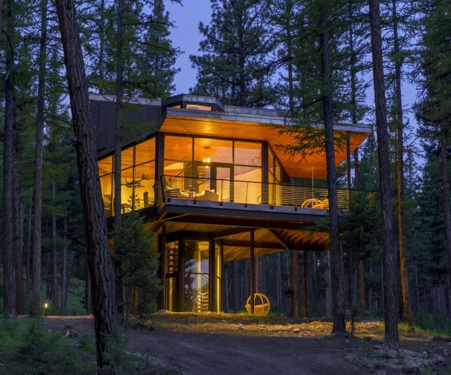 Outside view of Tree Haus at dusk, a modern, three-floor accommodation in the forest