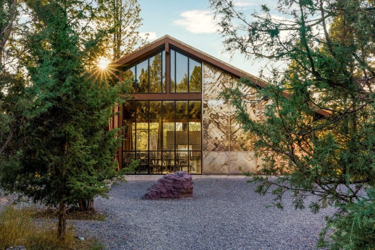 Outside view of Cliffside glamping Dining Pavilion, a stunning, modern dining experience with windowed walls and surrounded by forest